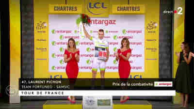 [image: a cyclist (male) with two girls around him on the victory podium and a third girl not too far]